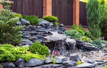 hardscape waterfall installed in a backyard